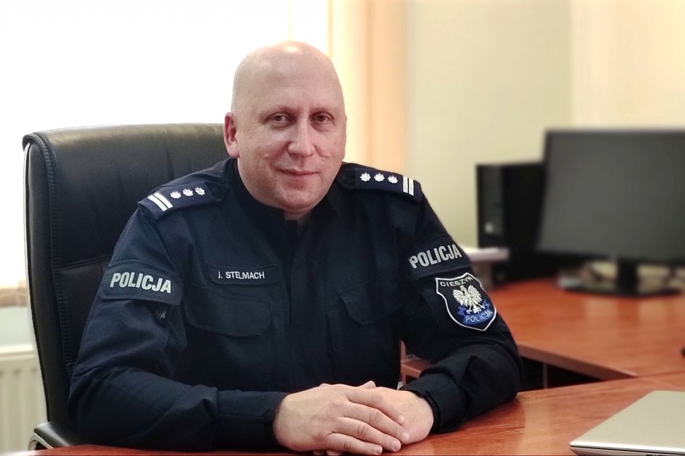 Komendant Powiatowy Policji w Cieszynie, siedzi za biurkiem 