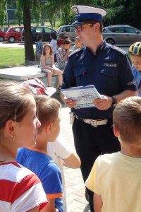 Policjant przeprowadza egzamin dla dzieci na kartę rowerową