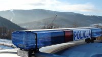 napis policja na dachu radiowozu, a w tle widok na góry