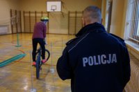 Zmagania uczniów na torze przeszkód pod czujnym okiem policjanta