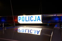 Podświetlony nocą napis policja na dachu radiowozu