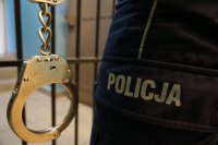 kajdanki i napis policja na policyjnym mundurze