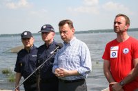 Szef MSWiA podczas konferencji nad Jeziorem Zegrzyńskim w sprawie bezpiecznego wypoczynku nad wodą. Towarzyszył mu Komendant Główny Policji nadinsp. dr Jarosław Szymczyk.