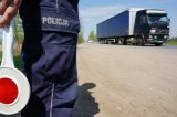 policjant ruchu drogowego a w tle samochód ciężarowy