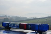 napis policja na dachu radiowozu, a w tle widok na góry