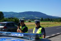 Policjanci sprawdzają prędkość pojazdów na drodze za pomocą laserowego miernika prędkości