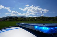 napis policja na dachu radiowozu, a w tle widok na góry