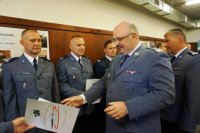 nadinsp.Krzysztof Justyński wręcza listy gratulacyjne policjantom