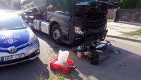 miejsce wypadku- uszkodzony motocykl leży na jezdni pod ciężąrówką