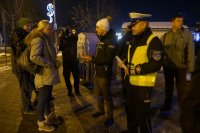 Kajetan Kajetanowicz i policjant rozdają odblaskowe elementy