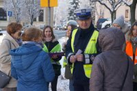 policjanci i uczniowie wręczają ciastka a prawidłowe zachowanie na drodze