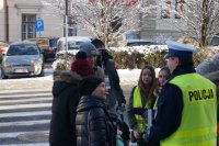 policjanci i uczniowie wręczają ciastka a prawidłowe zachowanie na drodze