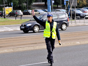 policjant na drodze daje ręką sygnał do zatrzymania