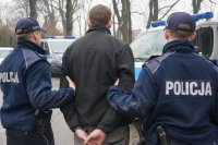 policjanci prowadzą zatrzymanego mężczyznę