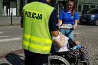 policjanci i uczniowie rozdają ciastka pieszym