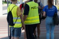 policjanci i uczniowie rozdają ciastka pieszym