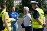 policjanci i uczniowie rozdają ciastka pieszym