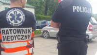 po lewej ratownik medyczny ( odwrócony tyłem) oraz policjant w tej samej pozie