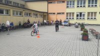 policjant przeprowadza egzamin na kartę rowerową, dziecko jedzie na rowerze, policjant ocenia