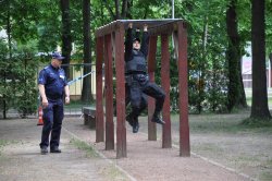 policjant pokonuje przeszkodę- drabinkę, drugi go ocenia