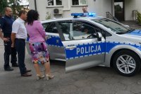 pzedstwiciele władz samorządowych i policjanci przy radiowozie