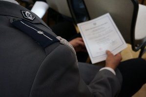 policjant trzyma w ręku akt mianowania