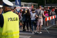 policjant pilnuje porządku na drodze na skocznię, w tle kibice