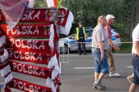 policjant pilnuje porządku na drodze na skocznię, w tle kibice