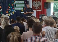 spotkanie z policjantem na hali sportowej, ludzie siedzą a policjant przemawia