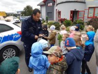 policjant rozdaje dzieciom odblaski