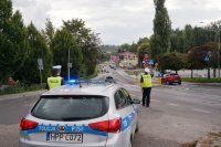 policjant zatrzymuje auto do kontroli, unosi tarczę i daje znak do zjechania