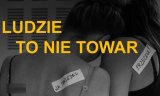 zdjęcie odwróconych ludzi oraz napis &quot;Ludzie to nie towar&quot;