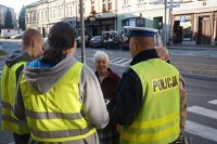 policjanci i uczniowie wręczają ciastka