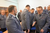 komendant dziękuje policjantowi, wyciąga rękę