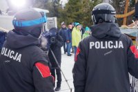 Mateusz Ligocki trzyma opaskę , pozuje do zdjęcia z żoną i policjantem