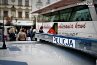 policja i autobus krwiodawstwa w tle