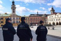 policjant istrażnicy miejscy stoją i patrzą na rynek