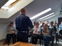 policjant rozmawia z seniorami i rozdaje odblaski