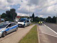 policjant po lewej i inspektor ITD po prawej stoją na drodze i kontrolują