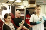 mężczyzna i kobieta oddają krew- siedzą, po prawej stronie stoi pielęgniarka