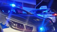 radiowóz policji , w tle samochód z napisem Radio Bielsko, noc, włączone niebieskie światła błyskowe radiowozu