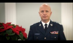 Komendant Główny Policji insp.gen. Jarosław Szymczyk w mundurze, po lewej czerwone kwiaty