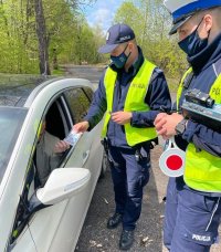 grafika- dzień, policjanci kontrolują kierowcę samochodu