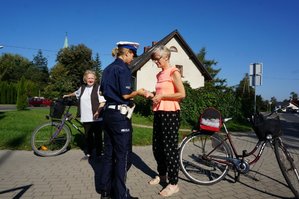 dzień, chodnik, policjantka rozmawia z rowerzystką-kobieta stoi obok roweru