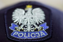grafika- policyjna czapka z daszkiem, widoczne godło Polski Orzeł Biały oraz napis policja