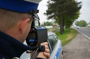 policjant mierzy prędkość, dzień , droga, auto