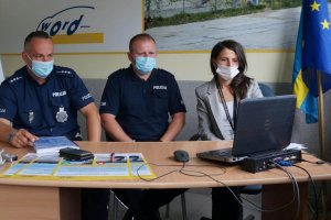 dwaj policjanci, kobieta, siedzą, patrzą na monitor