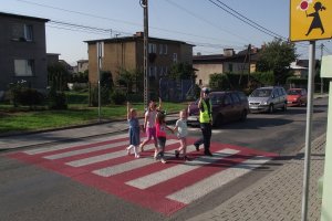 policjantka prowadzi dzieci przez przejście dla pieszych, dzień