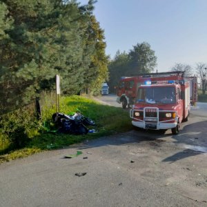 uszkodzony motocykl na poboczu, dzień, obok samochód straży pożarnej