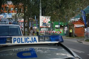 dzień, radiowóz policji, w tle szlaban kolejowy